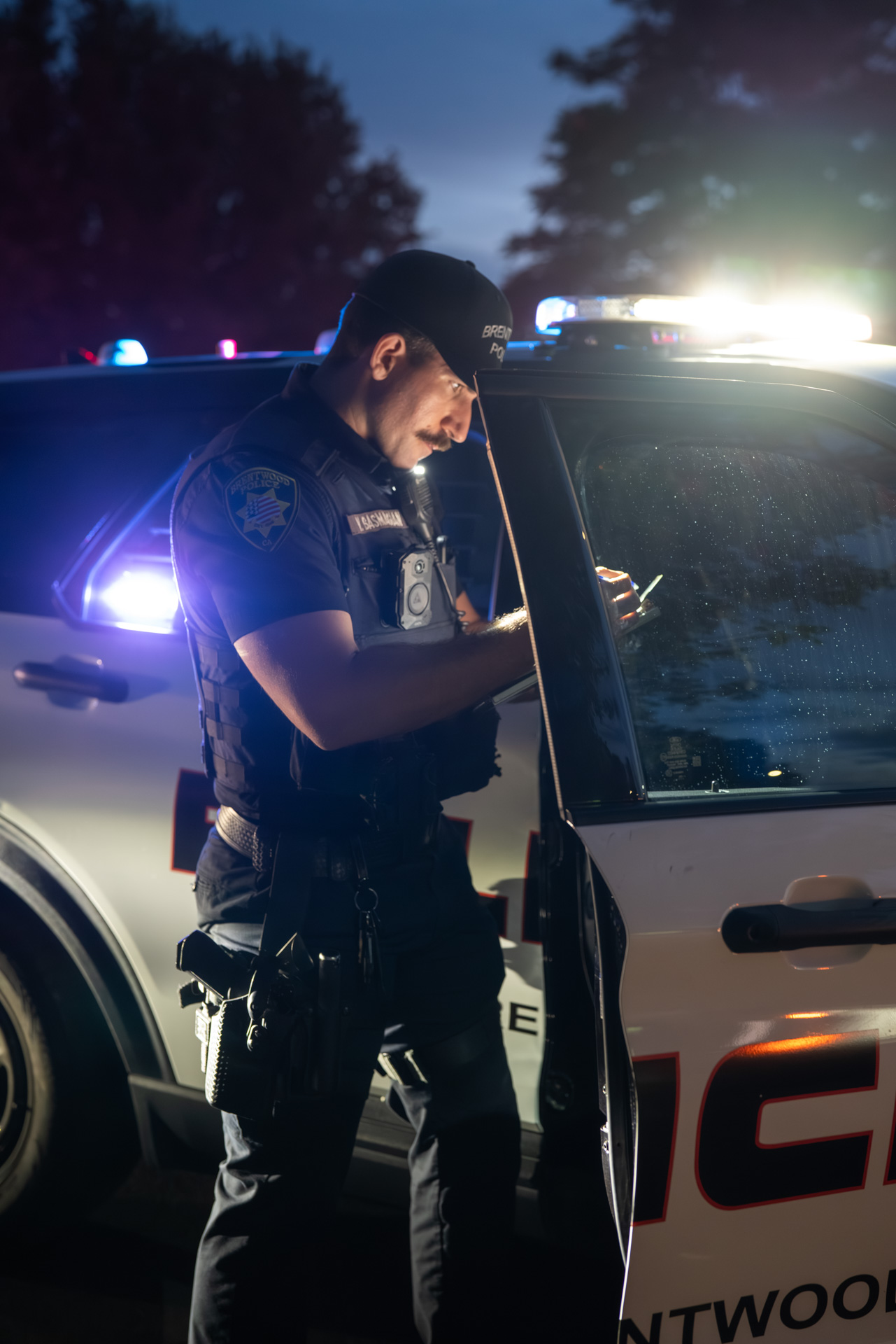 Officer making notes beside patrol SUV at night